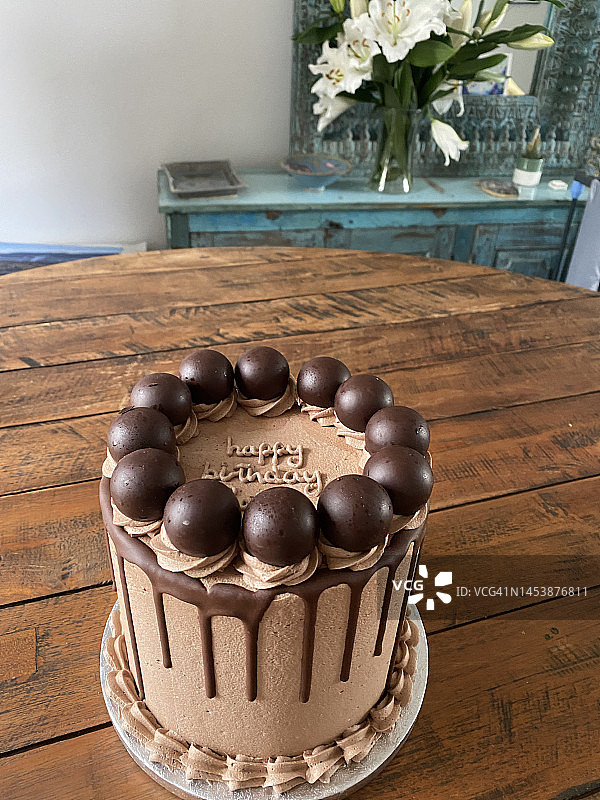 2022年2月伦敦优雅住宅内木制餐桌上的美味有机巧克力生日蛋糕图片素材