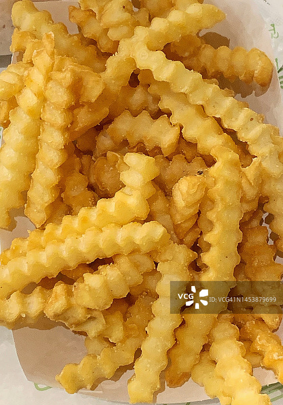 新鲜炸制的金黄色皱纹薯条图片素材
