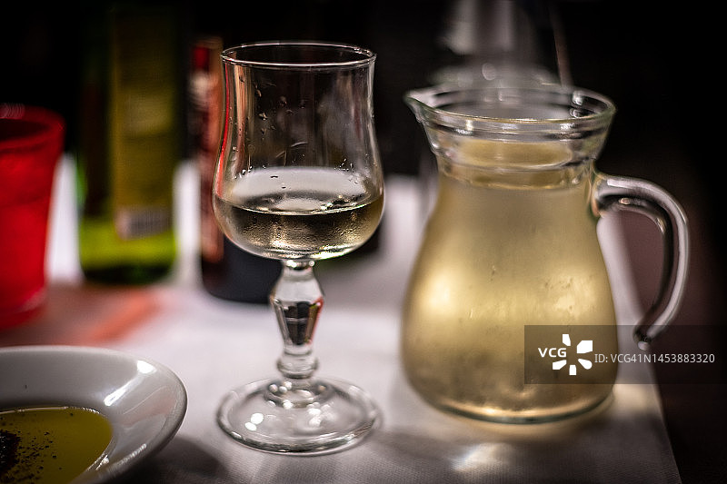 餐厅餐桌上的一杯白葡萄酒与玻璃水瓶图片素材