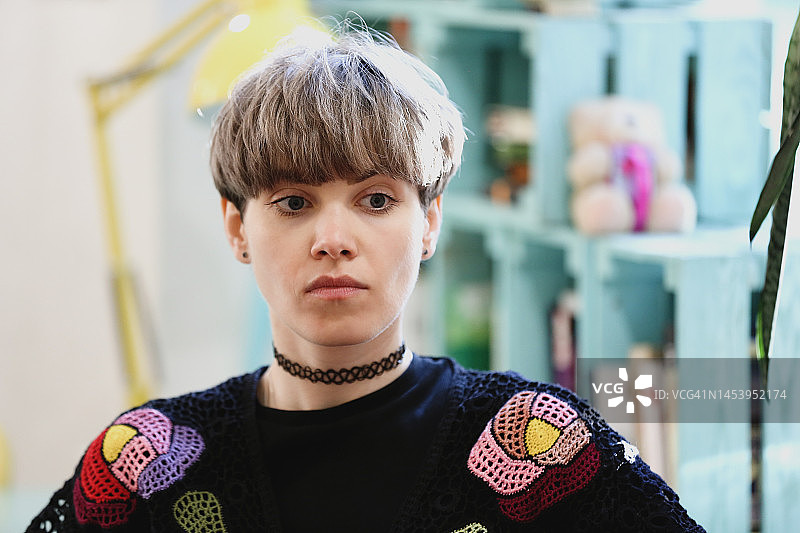 以色彩缤纷的当地咖啡馆为背景的年轻美丽女子肖像图片素材