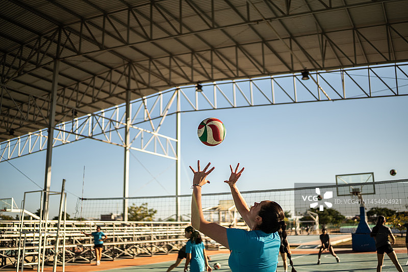 女排运动员在运动场热身时击球图片素材