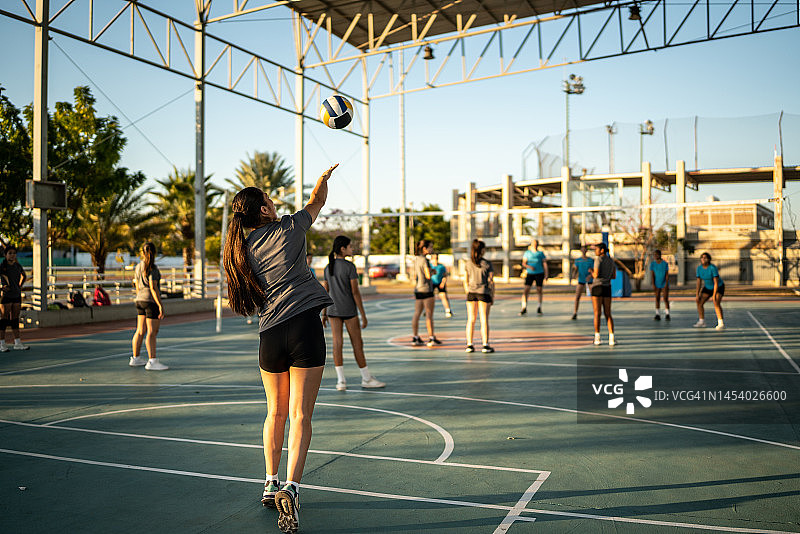 在运动场上发球的女性排球运动员图片素材