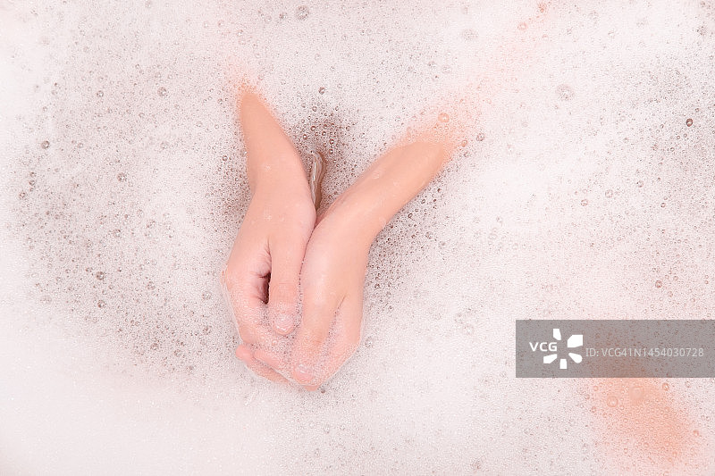 在浴室里，手在肥皂水上图片素材