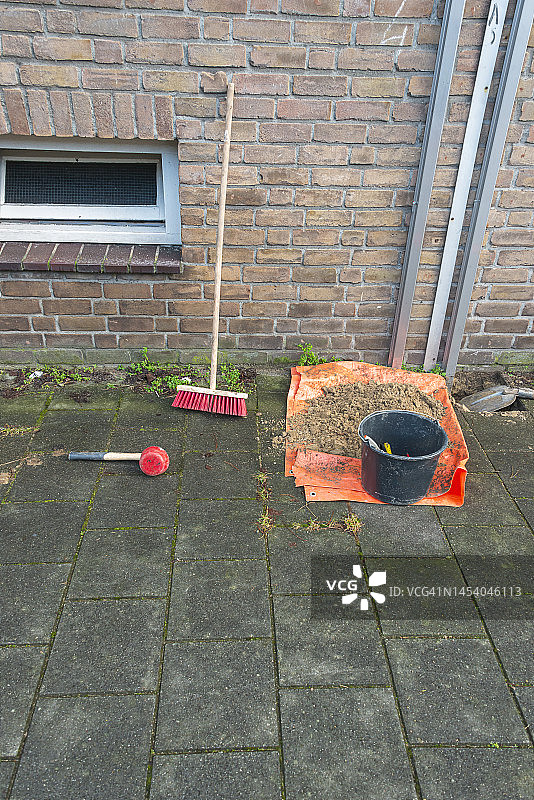 人行道上的扫帚、橡胶槌、黑色水桶和铲子图片素材