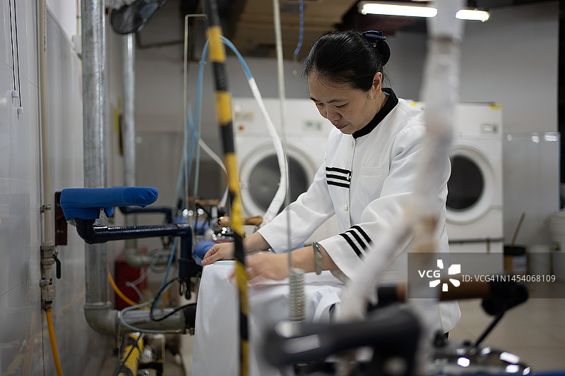 在洗衣房工作的亚洲女工人图片素材