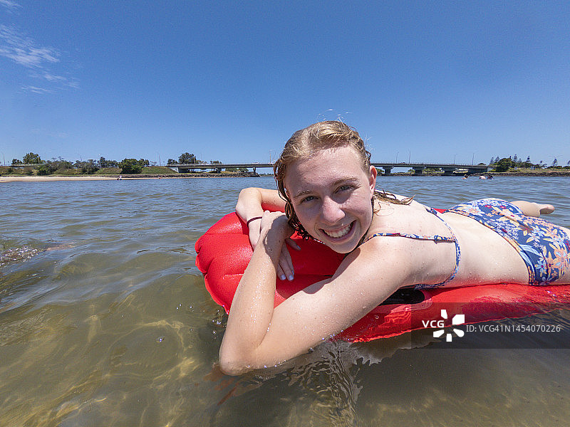 少女在海滩游泳，玩得很开心图片素材