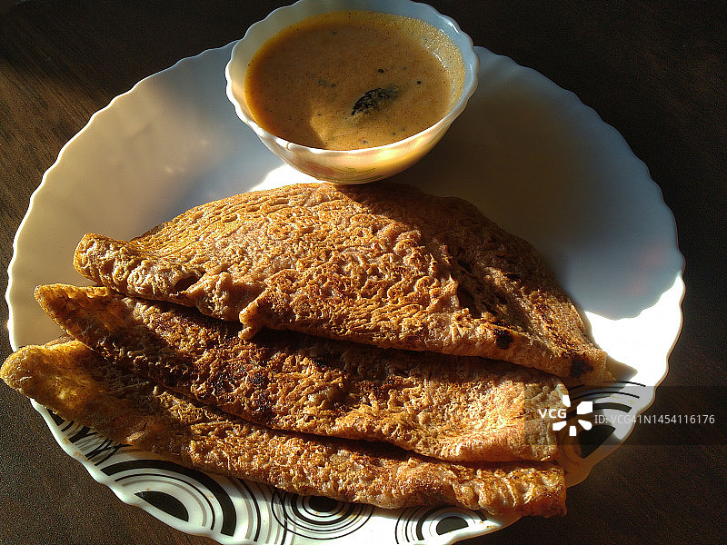 用陶瓷盘盛放的拉吉/手指小米和全麦Dosa配椰子酸辣酱图片素材