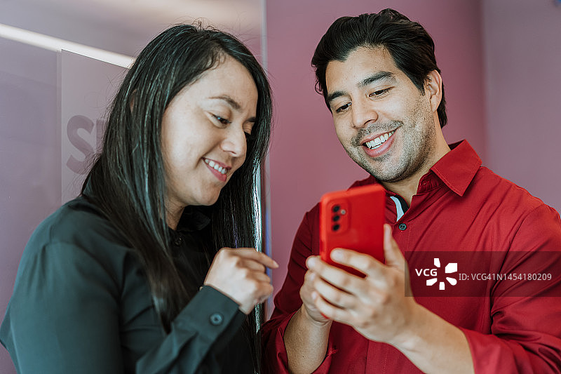 两位同事看智能手机图片素材