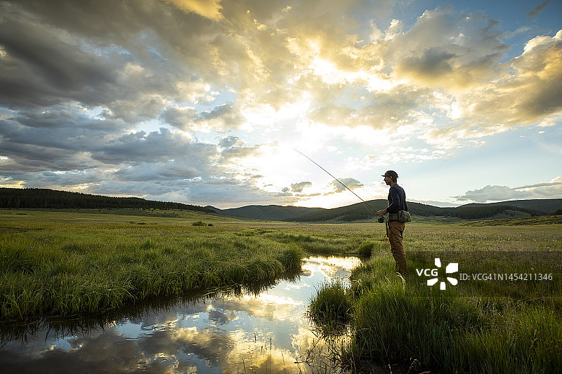 男人在小溪岸边飞蝇钓图片素材