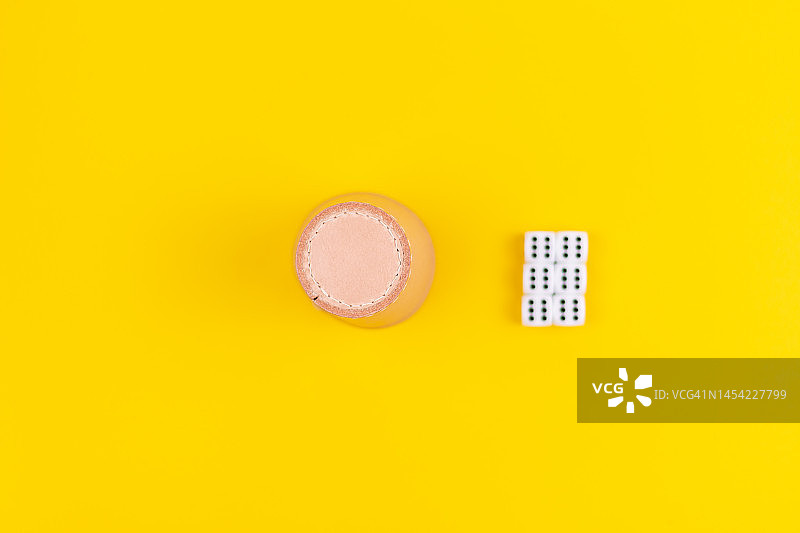 黄色背景上的骰盅和骰子图片素材