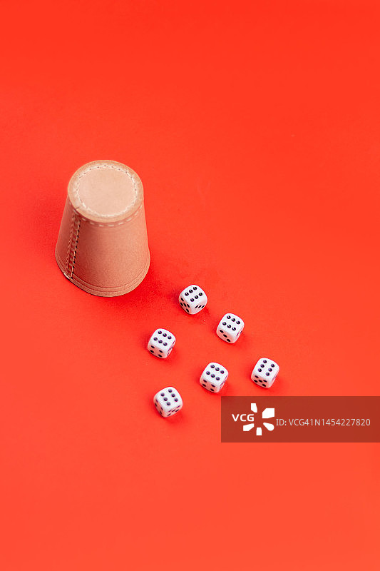红色背景上的骰盅和骰子图片素材