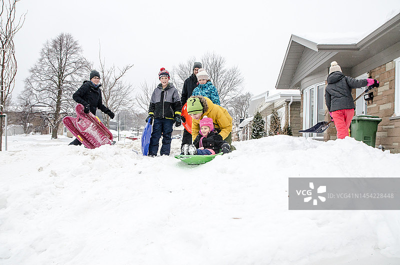 孩子们和父母在雪地滑行图片素材