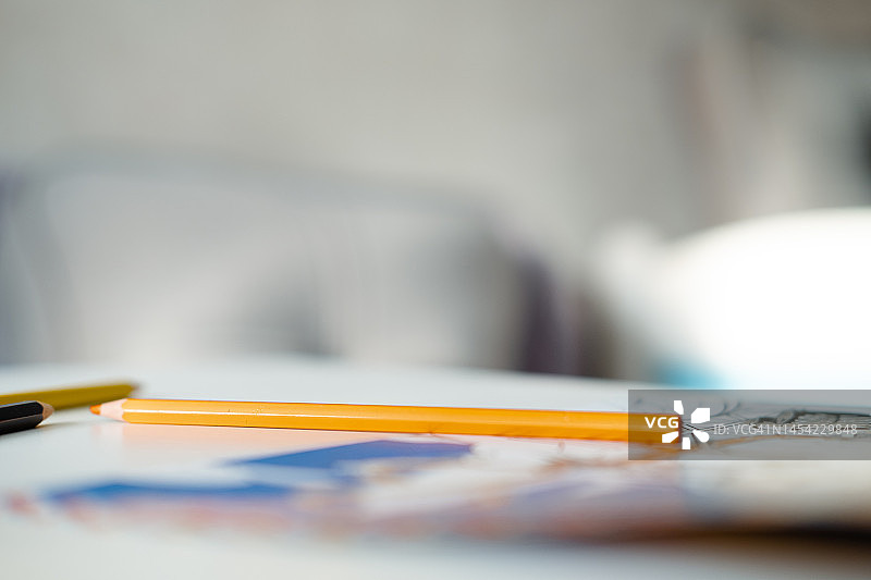 儿童涂色本上的橙色铅笔特写图片素材