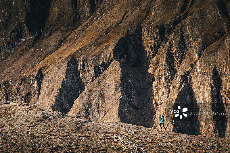 越野跑者在山间小径奔跑远景图片素材
