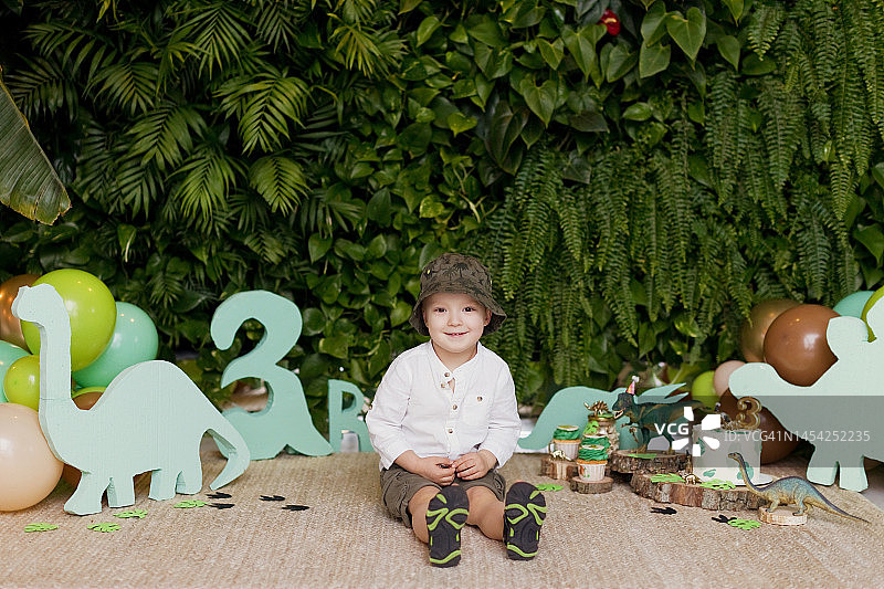 白人男孩坐在生日装饰旁图片素材