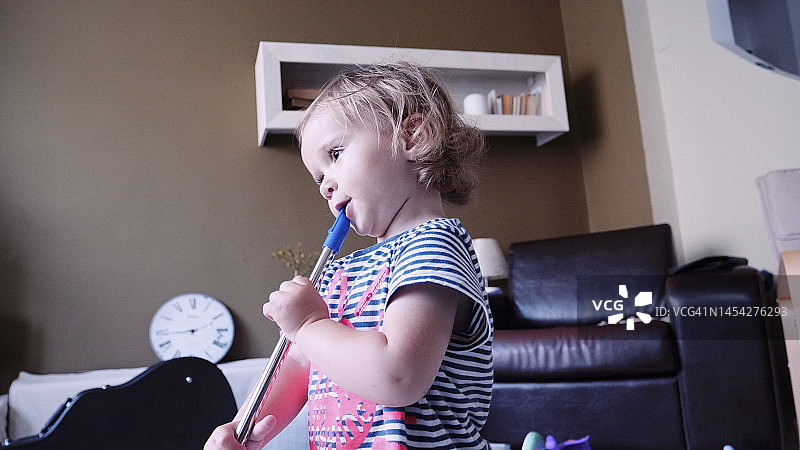 婴儿在家学习吹奏小笛图片素材