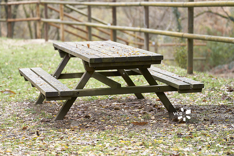 户外露营木桌与竹栅栏，树木背景图片素材
