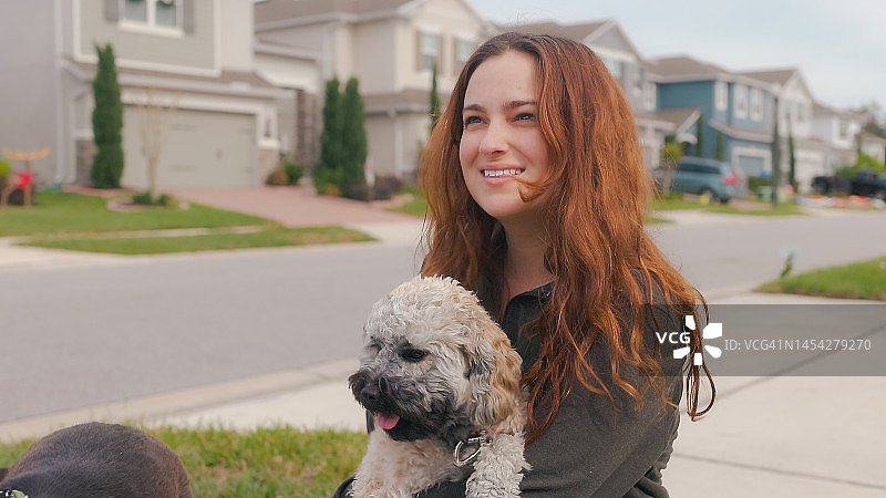遛狗时抚摸狗狗 - 宠爱狗狗 - 在社区遛狗 - 真诚拥抱 - 贵宾犬混血图片素材
