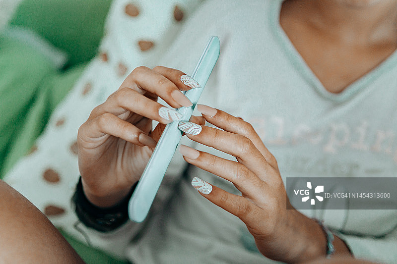 特写：女人修长手指涂抹指甲油图片素材