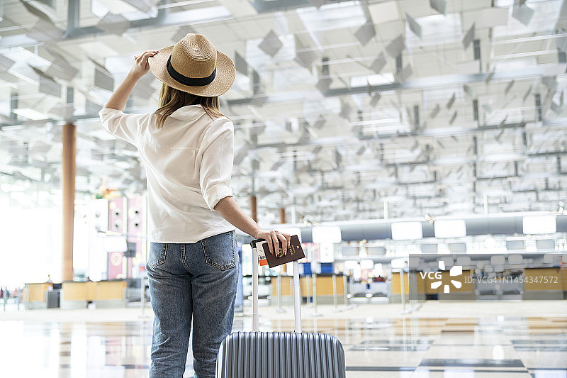 在机场航站楼里拉着行李箱的女人图片素材
