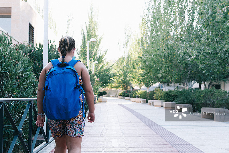 背着蓝色背包去上学的金发女孩图片素材