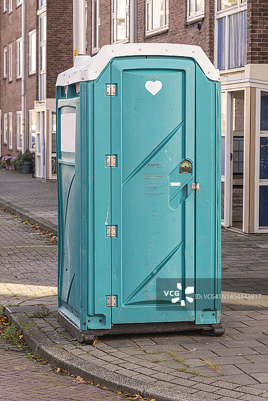 公寓楼旁人行道上的便携式卫生间图片素材