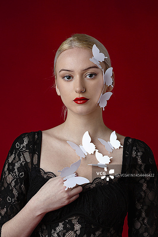 一位脸上和身上有蝴蝶的美丽女子的美容照图片素材