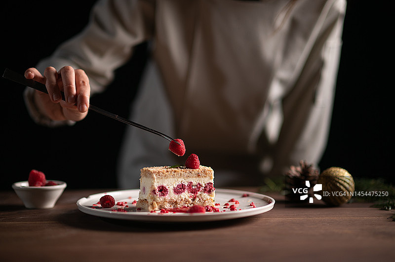 女厨师用草莓装饰芝士蛋糕图片素材