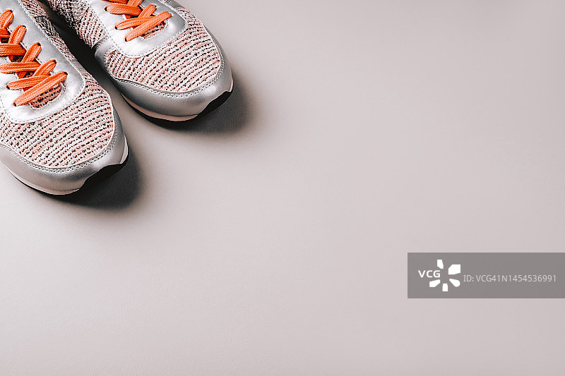 浅灰色背景上的灰色女士运动鞋图片素材