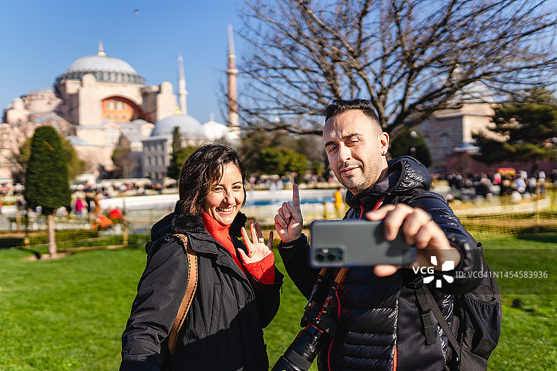 年轻游客情侣在圣索菲亚大教堂拍照图片素材