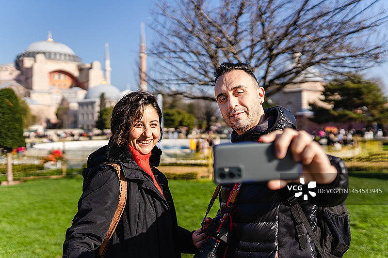 年轻游客情侣在圣索菲亚大教堂拍照图片素材