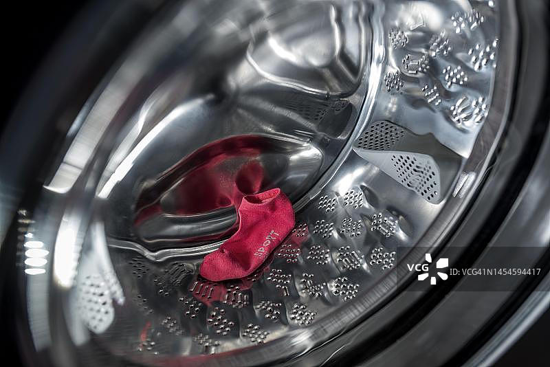 德国洗衣机里的单只红色运动袜图片素材