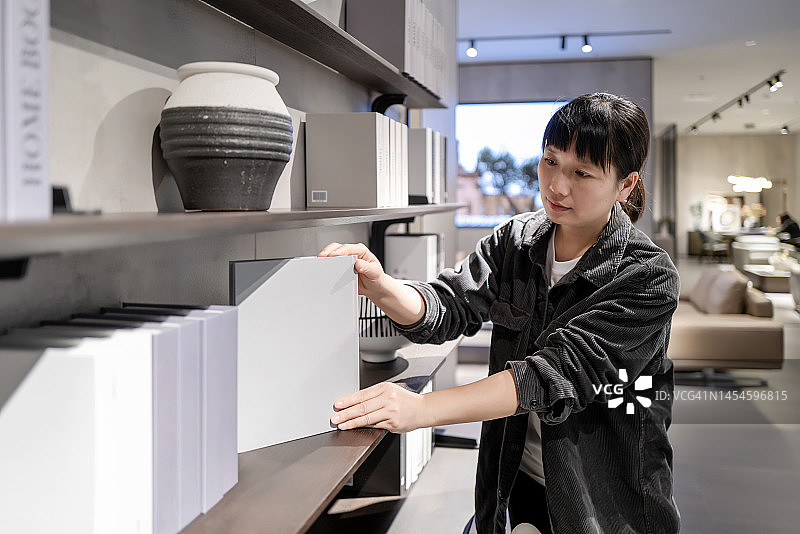 一位女士在家整理书架图片素材