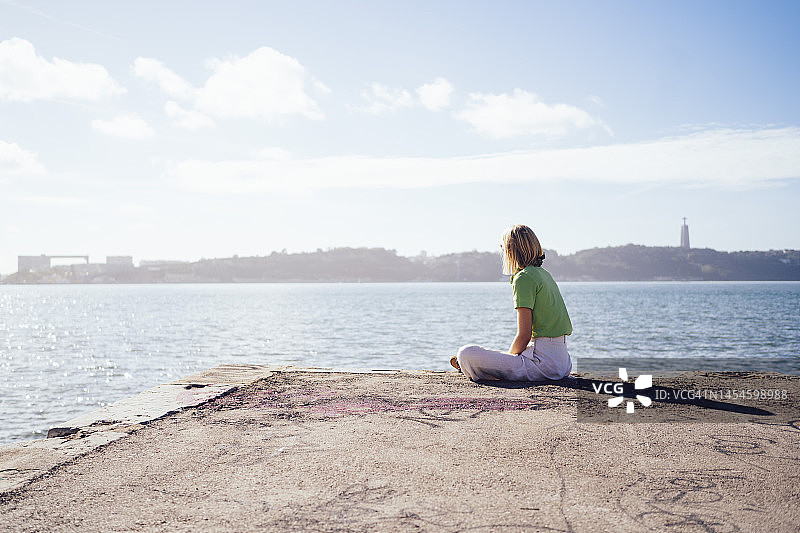 在码头上冥想的年轻女人图片素材