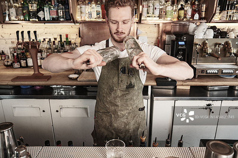 在酒吧工作的年轻红发男招待图片素材