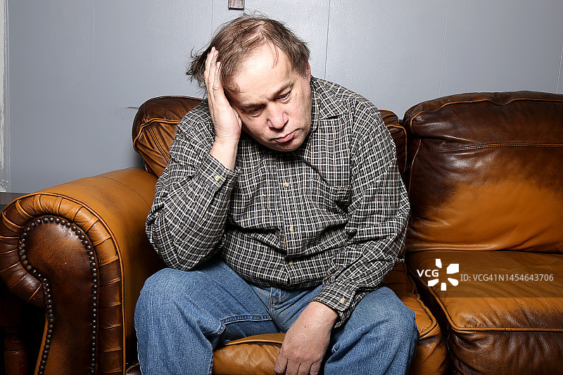 面色严肃的患有自闭症和学习障碍的中年男子图片素材