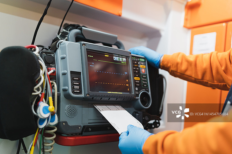 救护车内，医护人员使用除颤监护仪的照片图片素材