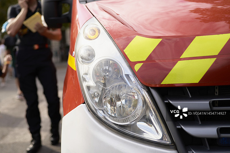 穿制服的男人手持物品，另一只手呼喊，站在相关车辆旁，向有关部门报告图片素材