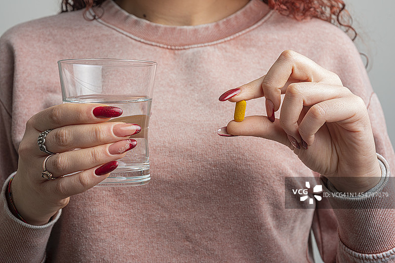 女人拿着药丸和水图片素材