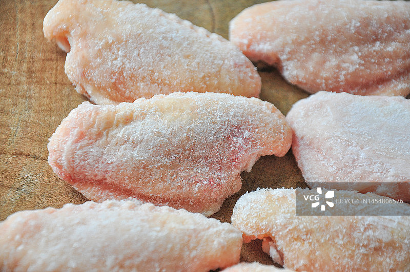 砧板上的冷冻生鸡翅图片素材