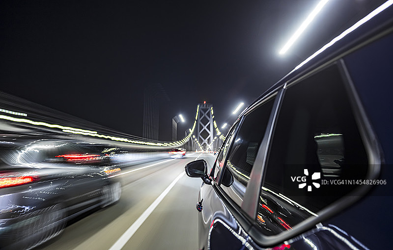 夜幕下，旧金山标志性海湾大桥上的混合动力汽车图片素材