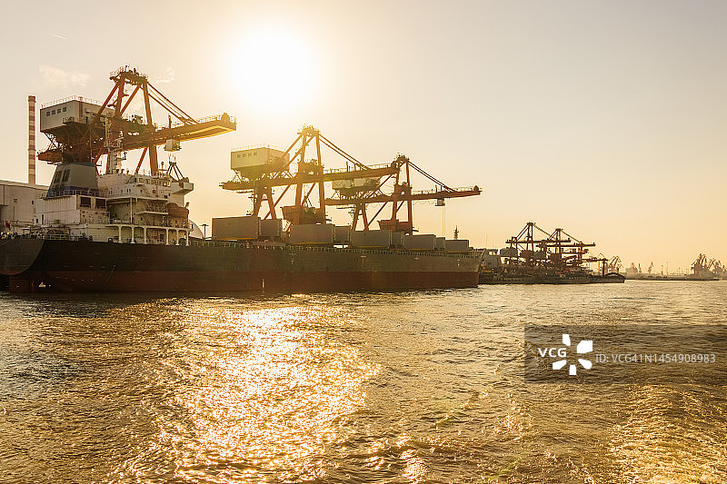 江苏江阴港口，起重机和货轮正在装卸货物图片素材