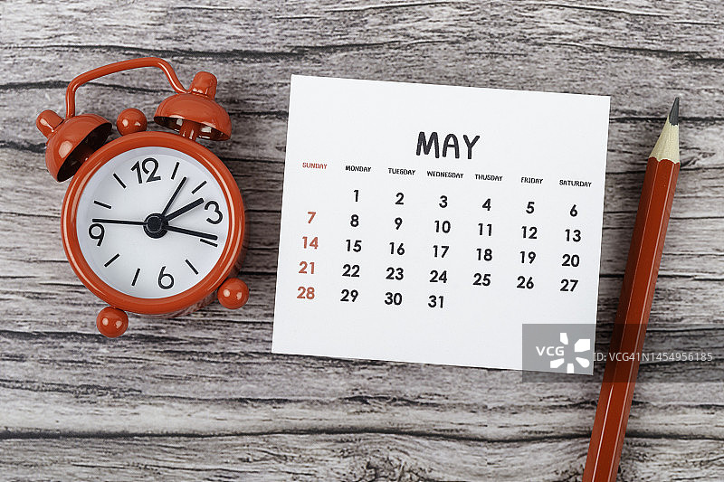 2023年台历：5月，规划与截止日期，闹钟和红色铅笔，木桌背景图片素材