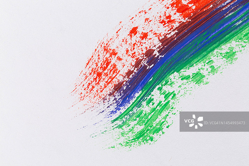 白色纸上的丙烯红蓝绿颜料，彩虹笔触图片素材