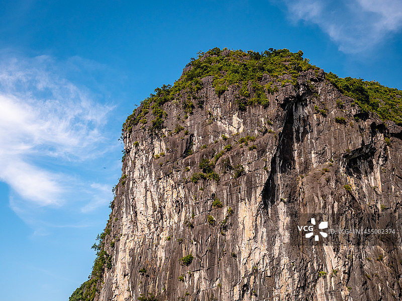 下龙湾越南邮轮在日落黄金时段拍摄联合国教科文组织千岛。绿树覆盖着岛屿和碧水。旅游和遗愿清单地点图片素材