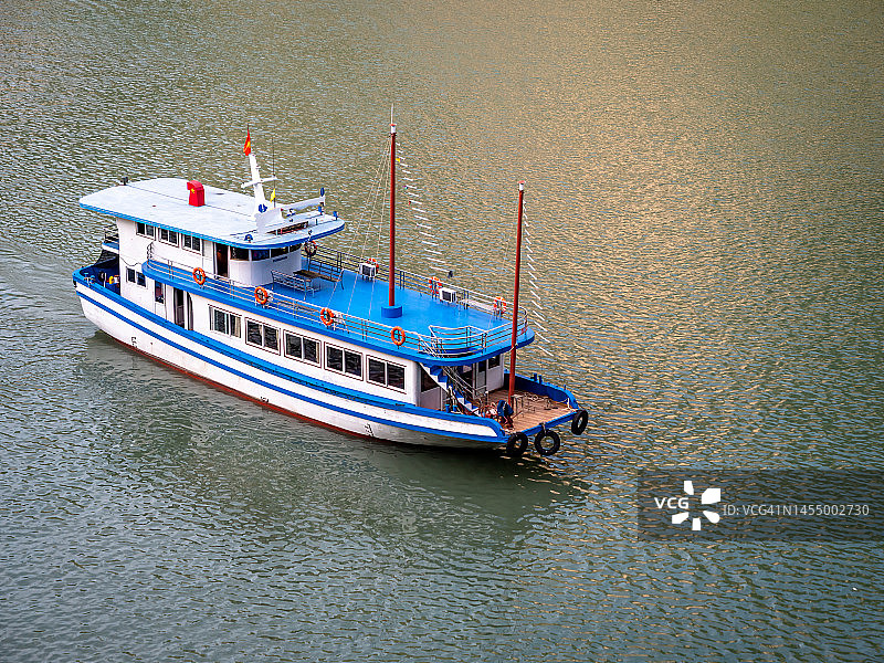 下龙湾日落时分的航拍镜头，乘坐游船穿梭于越南下龙湾，欣赏石灰岩悬崖和山脉的日落美景，感受宁静、自由的旅行和旅游概念（联合国教科文组织世界遗产地）图片素材