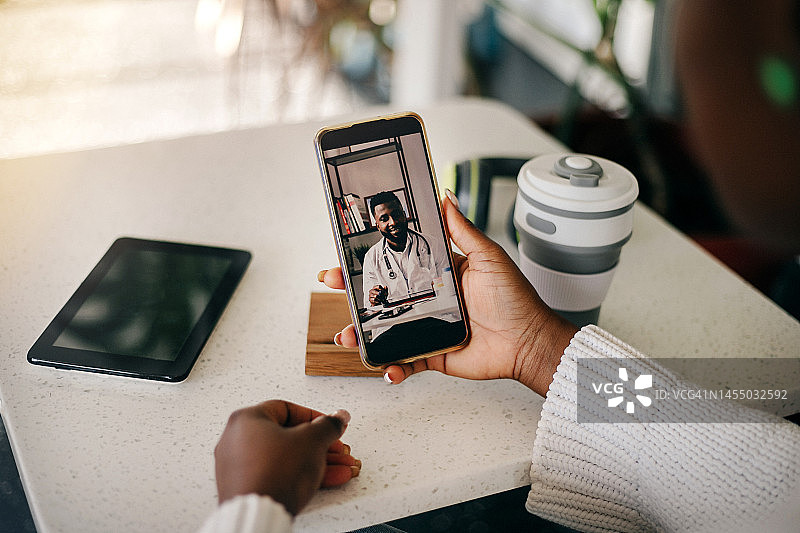 年轻的黑人女子在家中与医生进行视频通话图片素材