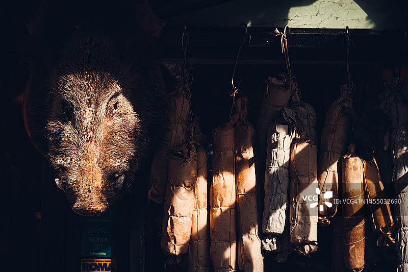 带有野猪头和悬挂香肠的肉铺橱窗，意大利罗马图片素材