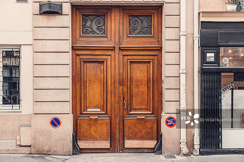 巴黎林荫大道上经典住宅建筑的木制双开门图片素材