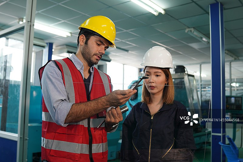 经理和技术工人在高科技企业检查机器零件图片素材